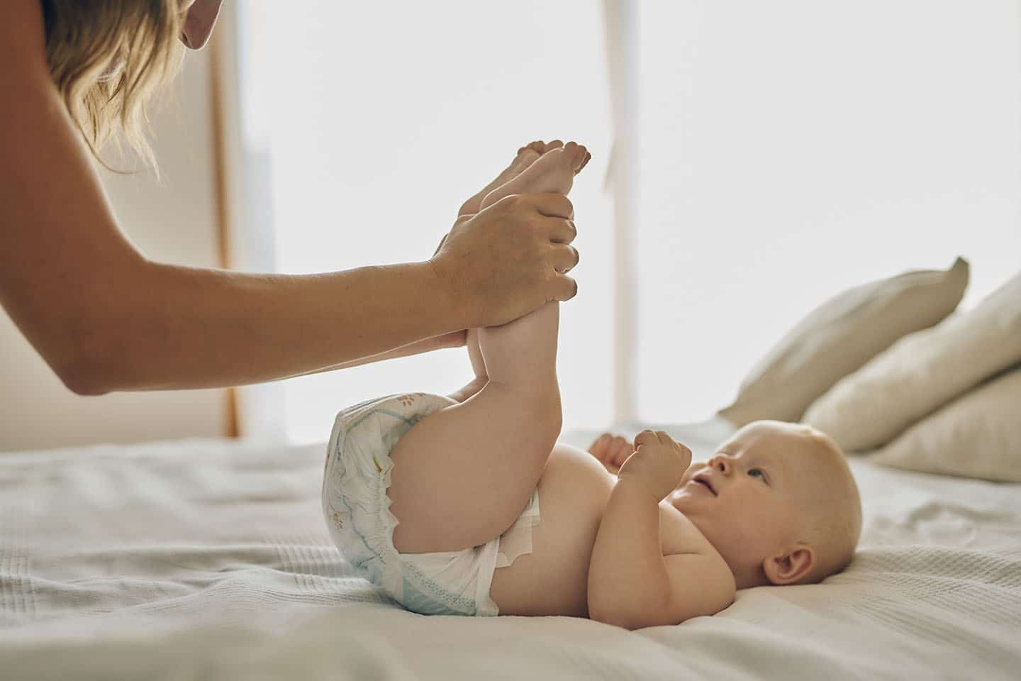 beba na stolu s nogama u zraku i pelena. presvlačenje