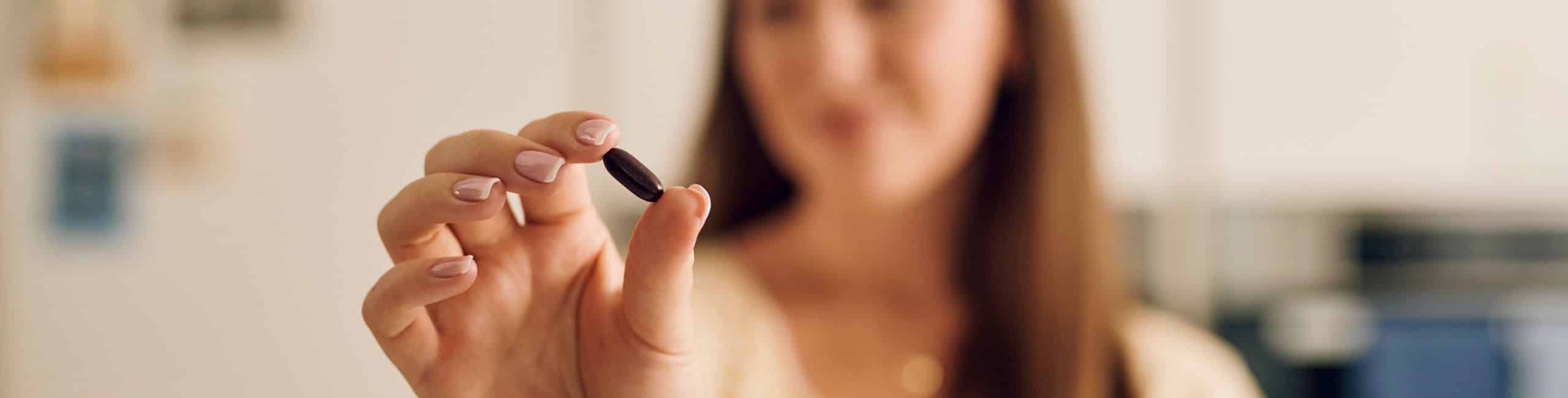 Žena drži kapsulu Novalac prenatala s mikrokapsulama željeza Lipofer