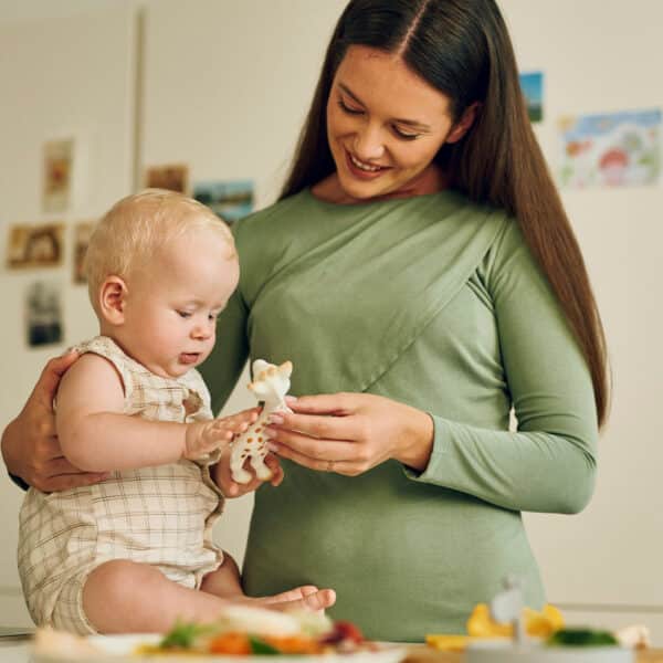 Majka s bebom u kuhinji igra se s popularnom žirafom - bezbrižni trenuci bez brige o alergijama